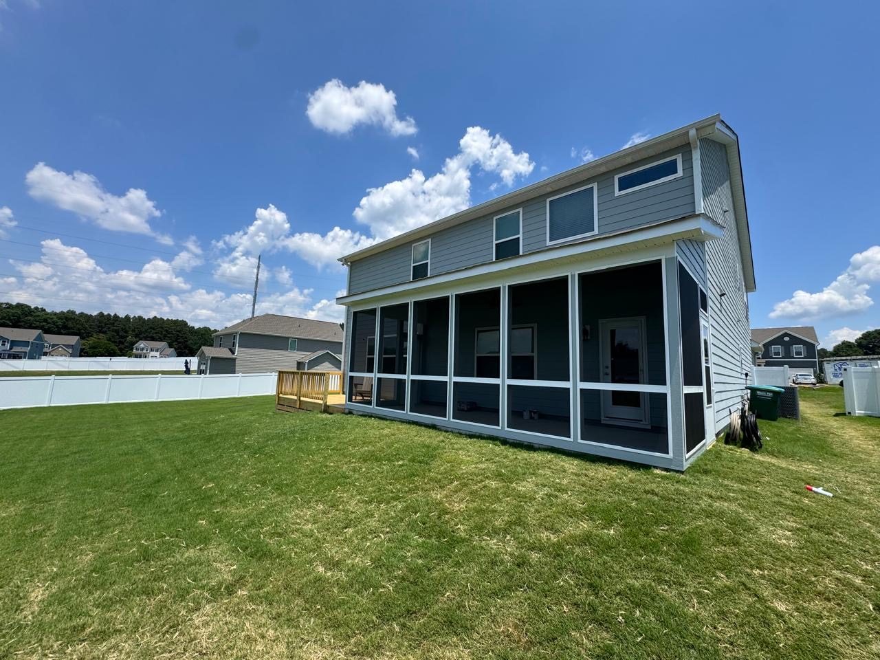 Screened porch addition running across the back of a two-storey home, with a wide lawn in front