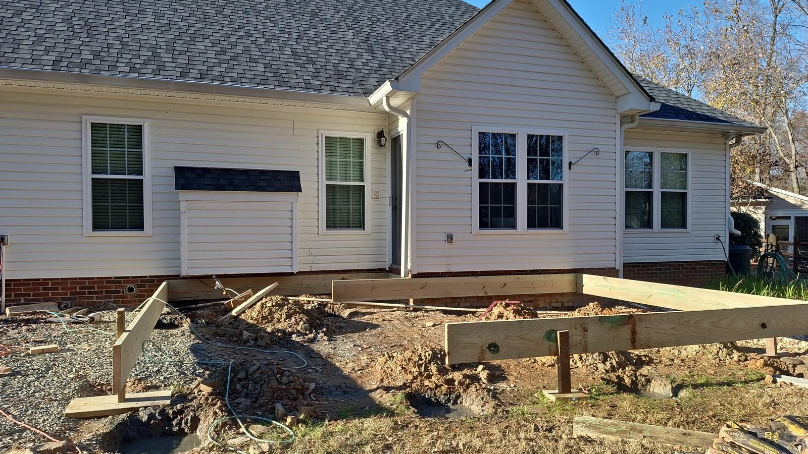 Deck framing rebuilt on new posts along the back of a brick home