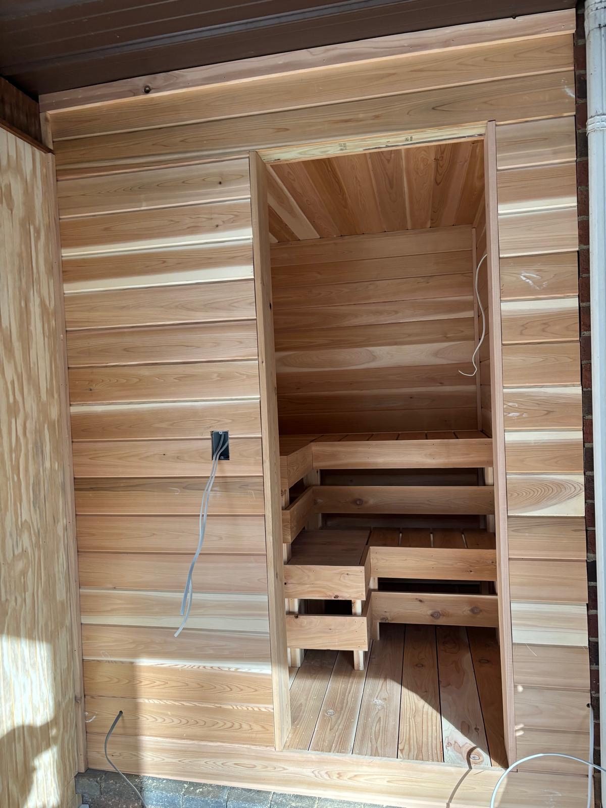 Custom cedar sauna interior showing the bench framing and panelling