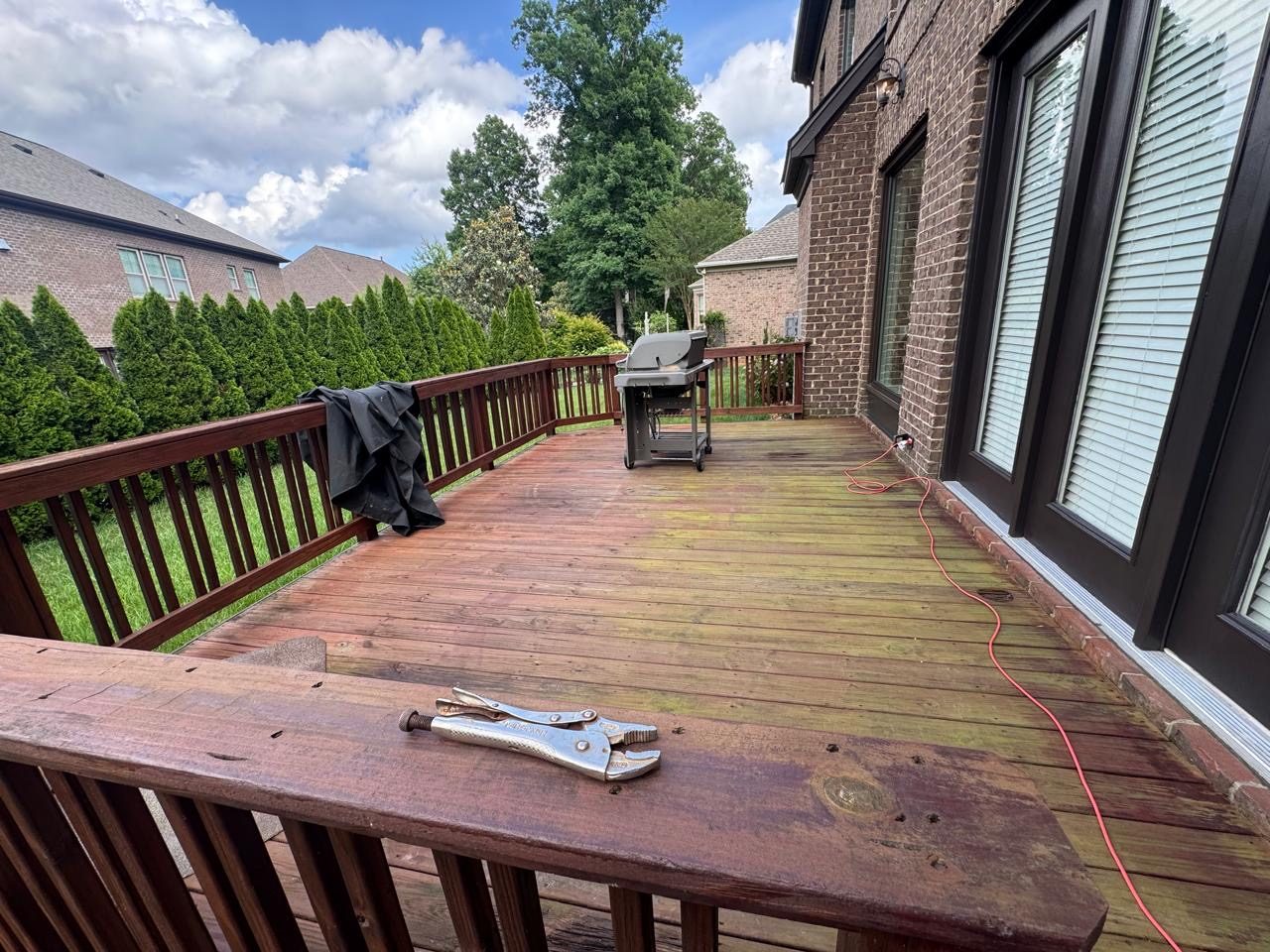 A weathered deck before restoration, with algae spread across the boards